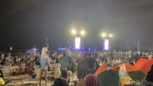 Hujan Tak Surutkan Semangat Warga Nikmati Konser Dewa 19 di Ancol Sambut Tahun Baru